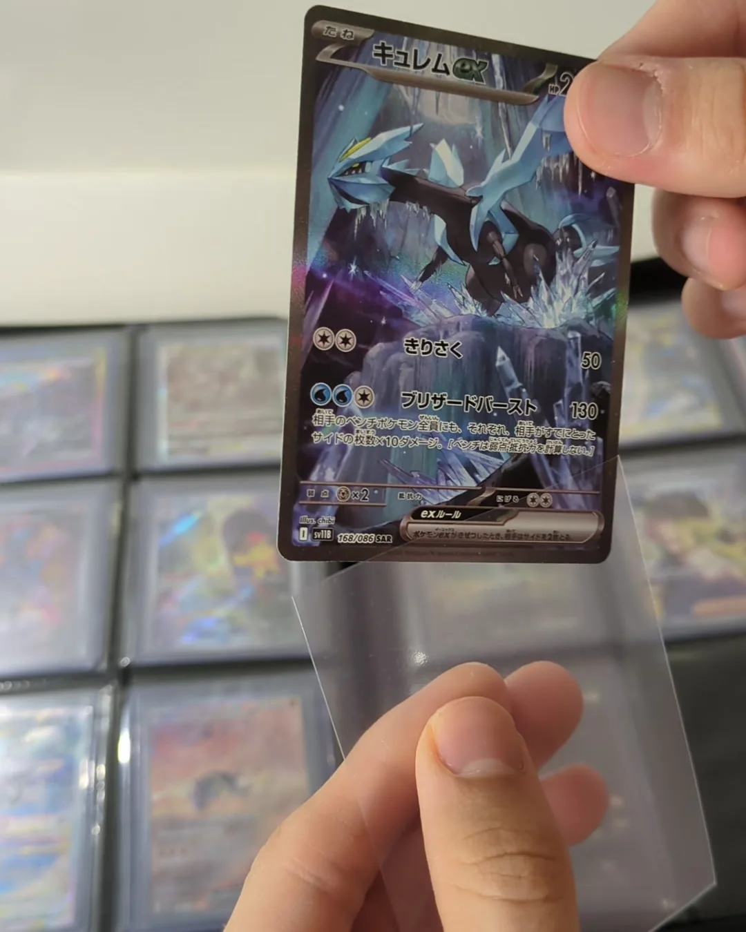 Carta Pokémon japonesa entrando en una funda de polipropileno
